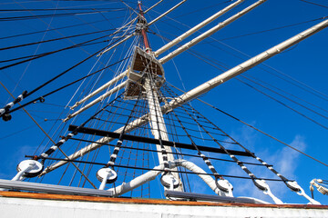 Fototapeta premium Rigging and mast of a large sailing ship. Ropes and pulleys for tensioning sails.