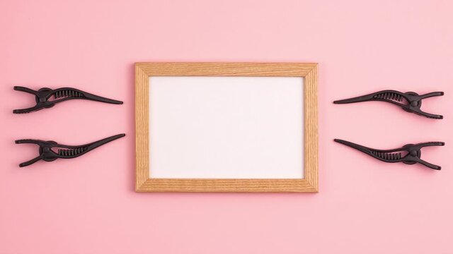 Stop motion animation mockup wooden frame flat lay of four black section hair clips of the right and left of the frame template with copy space on pink. Hairdresser salon equipment concept, premium