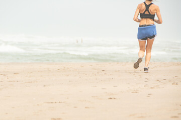 Fototapeta na wymiar woman running doing physical exercises on the beach