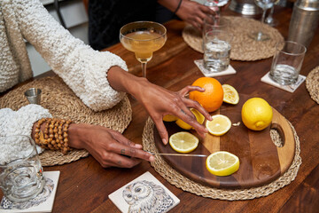 Black hands slicing fruit for mocktail drinks