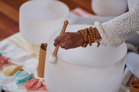 Black woman playing sound bath drums for mediation