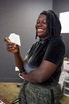 Black woman creative looking at card stock for art project