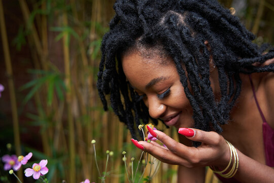 Black woman enjoying plants in garden
