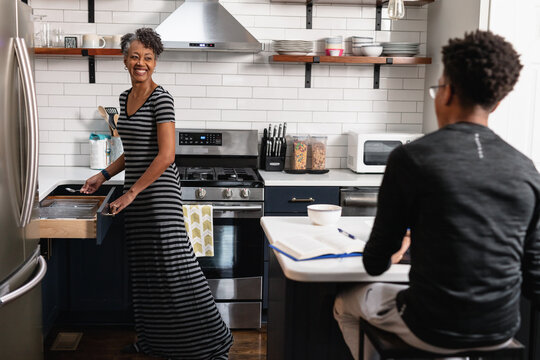 Mom grabbing silverware for food in kitchen