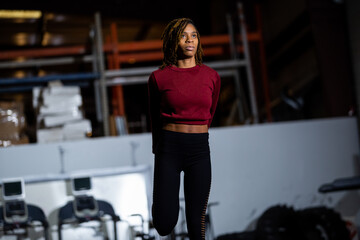 Black fit woman stretching and doing exercises at gym