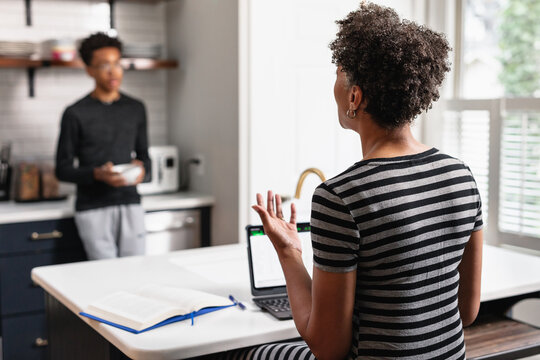 Mother And Son Having Leisure Conversation In Kitchen At Home, Saturday Morning