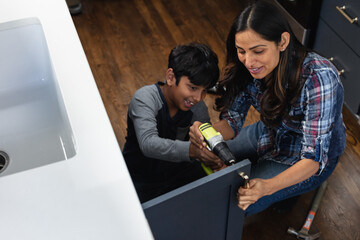 Indian mother teaches son how to repair kitchen cabinets, DIY home improvement