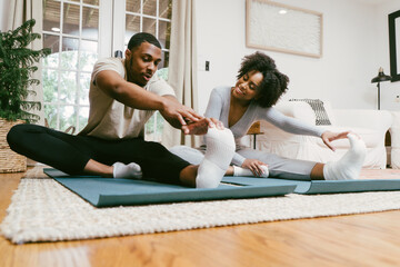 Black couple stretches and workout at home together