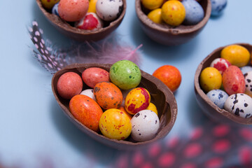 Close up  chocolate eggs on blue background Easter hunt sweets concept