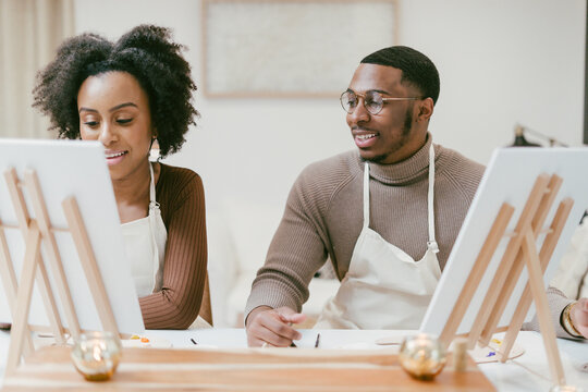African American couple enjoys at home painting and craft date night, DIY