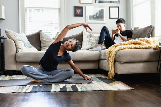 Black woman stretching and exercises in family living room