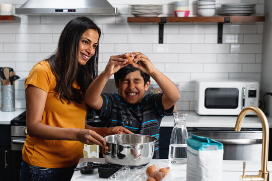 Indian mom and son cooking and baking in the kitchen