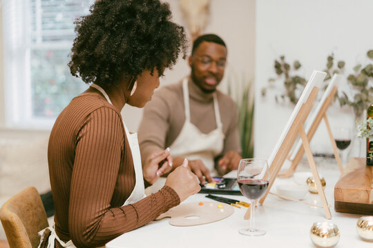 Black couple having at home date night, painting romantic DIY