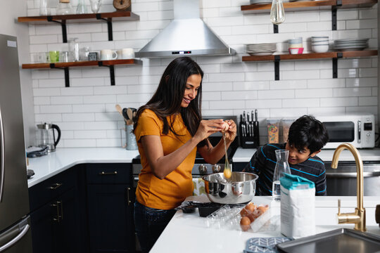 Indian Mom And Son Cooking And Baking In The Kitchen