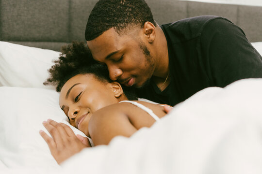 Boyfriend waking up girlfriend from sleep, weekend morning