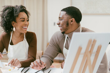 Black couple has fun painting and laughing during date night, paint and craft DIY