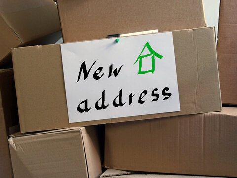 moving boxes and a sheet of paper with the inscription "New address"