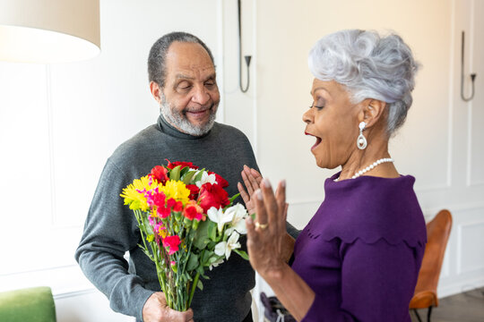Senior man surprises wife with flowers, celebrating valentines day