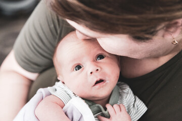 Adorable newborn baby girl lovingly looking up at mother