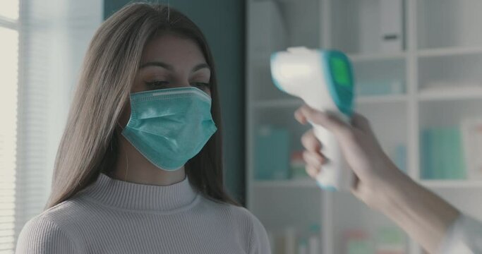 Doctor measuring a woman's body temperature