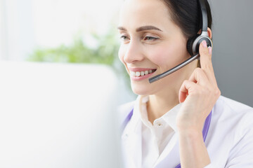 Smiling doctor operator at workplace is providing medical assistance remotely