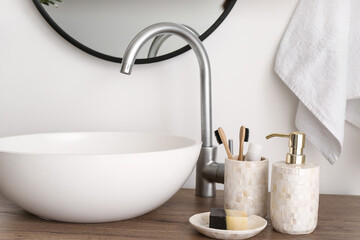 Soap with toothbrushes near sink in bathroom