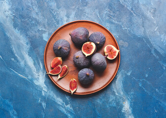Tray with fresh figs on color background