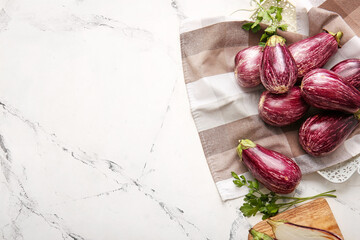 Composition with fresh eggplants on light background