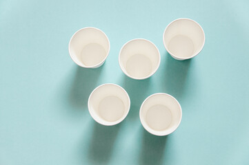 disposable white kraft paper cups stand on blue background
