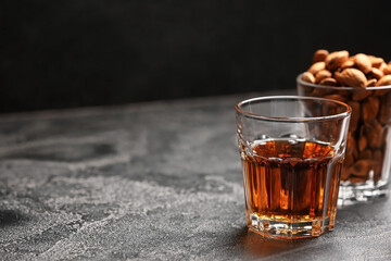Glasses of almond liquor and nuts on dark background