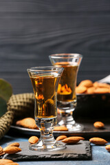 Composition with glasses of almond liquor and nuts on dark wooden background