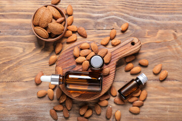 Fototapeta na wymiar Bottles with almond oil on wooden background