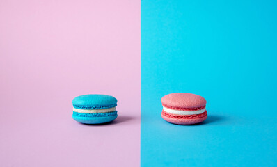 Bright blue macaroon cookies with white cream on a pink background bright pink macaroon cookies with white cream on a blue background Gender party decoration horizontal photo