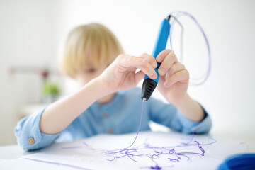 Little boy learning make model with 3d printing pen. Child playing with new modern toy for creativity. DIY. STEM and STEAM education.