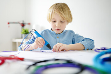 Little boy learning make model with 3d printing pen. Child playing with new modern toy for creativity. DIY. STEM and STEAM education.