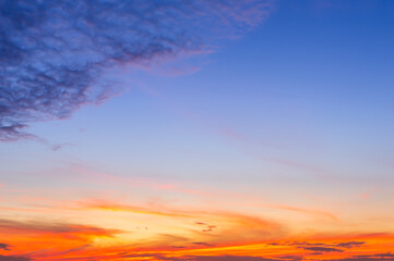 Beautiful sky painted by the sun leaving bright golden shades.Dense clouds in twilight sky in winter evening.Image of cloud sky on evening time.Evening sky scene with golden light from the setting sun