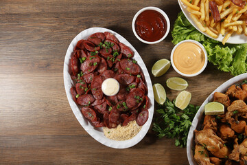 Portion of pepperoni sausage with lemon, fries, bacon and fried chicken. Lettuce, potato, green onion, ketchup and mayonnaise