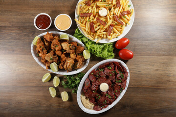 Portion of pepperoni sausage with lemon, fries, bacon and fried chicken. Lettuce, potato, green onion, ketchup and mayonnaise