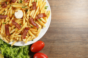 Portion of french fries with bacon. Lettuce, green onion, tomato, ketchup and mayonnaise