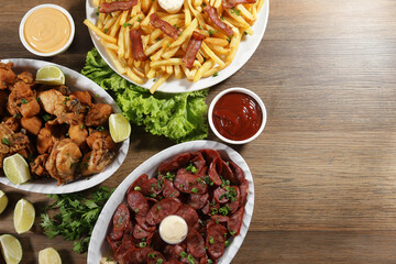 Portion of pepperoni sausage with lemon, fries, bacon and fried chicken. Lettuce, green onion, ketchup and mayonnaise