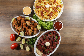 Portion of pepperoni sausage with lemon, fries, bacon and fried chicken. Lettuce, green onion, ketchup and mayonnaise