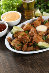 Portion of fried chicken with lemon. Lettuce, green onion, ketchup and mayonnaise