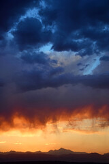 dramatic sunset over  long's peak and the front range of the colorado rocky mountains as seen from broomfield, colorado
