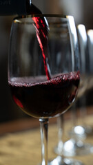 red wine falling into the glass goblet