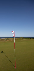 Obraz premium golf flag overlooking the ocean 