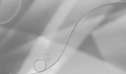 Closeup of oil and water droplets on grey colour light effect background.