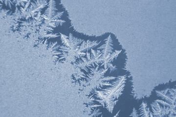 frosty patterns on the window glass closeup. natural textures and backgrounds. ice patterns on...