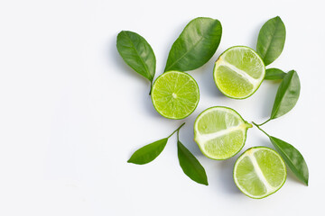 Fresh limes with green leaves on white background.