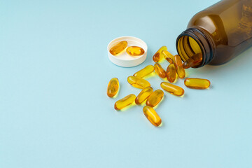 Fish oil tablet on a blue background with a copy space. Medical and health care concept.