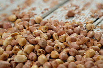 Close up peeling peanuts in bamboo basket on wooden table.